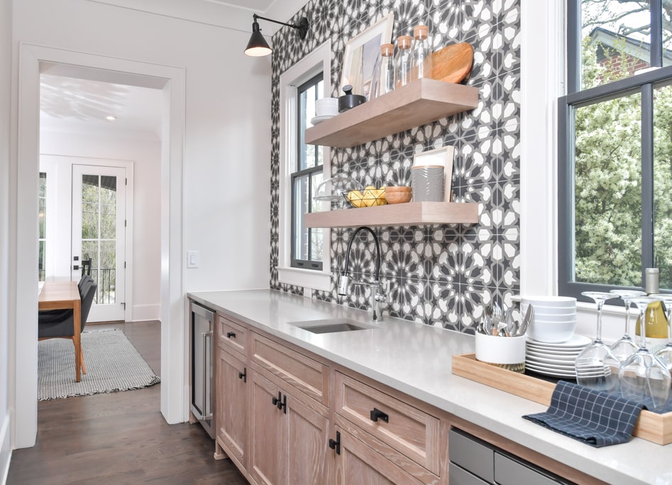 Fully functional butler's pantry with wooden open shelving and a patterned tile backsplash