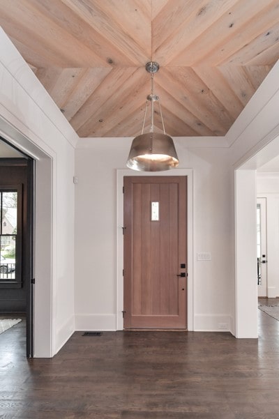Stunning foyer with a wood paneled ceiling and pendant lighting