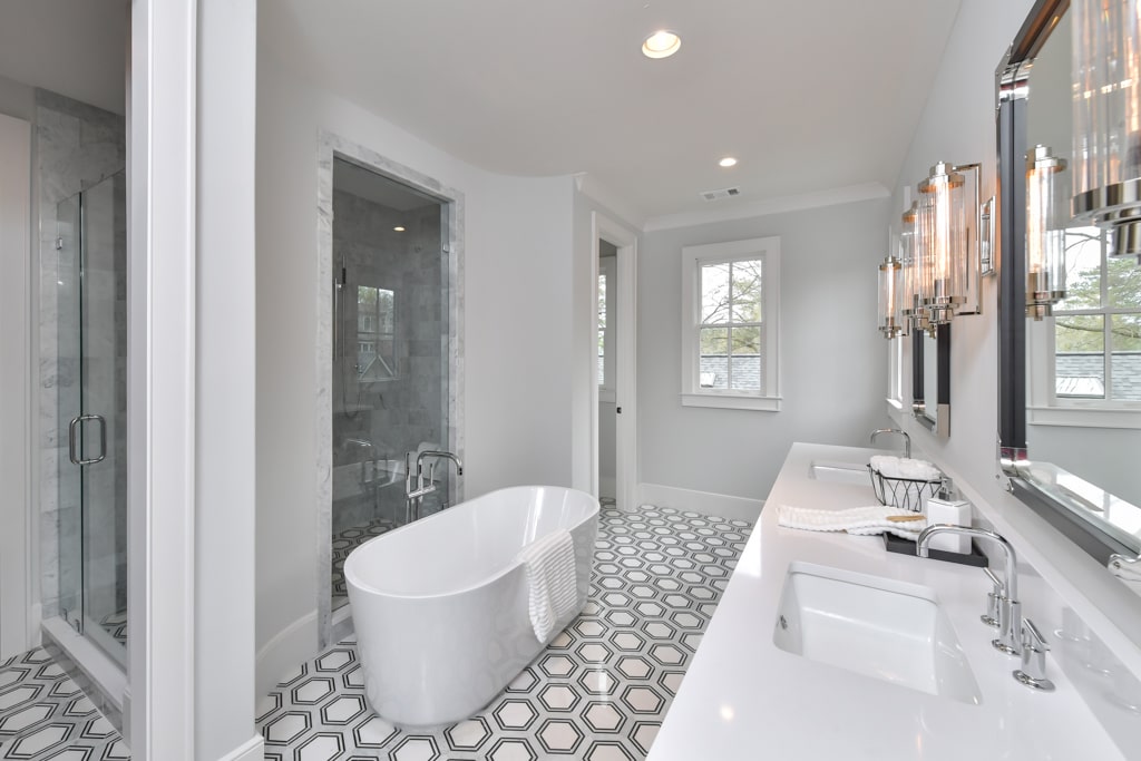 Master bathroom design with a modern soaking tub, glass door shower and geometric tile flooring